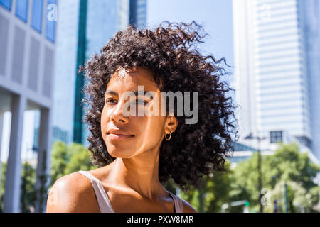 Deutschland, Frankfurt, Portrait von Inhalt junge Frau mit lockigem Haar Stockfoto