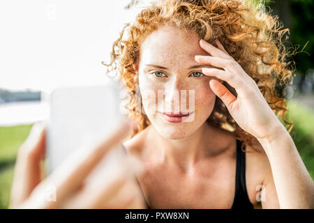 Portrait von Sommersprossige junge Frau unter selfie mit Handy Stockfoto