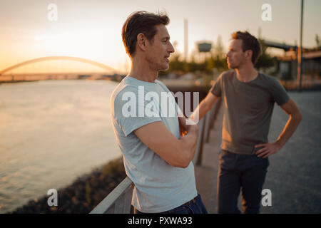 Zwei Freunde treffen bei Sonnenuntergang, am Abend reden Stockfoto