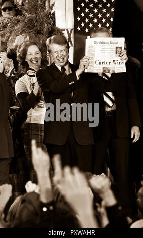 Carter cousin Betty Papst reagiert, als gewählter Präsident Jimmy Carter hält eine Zeitung mit der Schlagzeile ìCarter Winsî, wie er mit Massen füllen die Straßen von winzigen Plains, Georgia feiert, am Wahlabend. Stockfoto