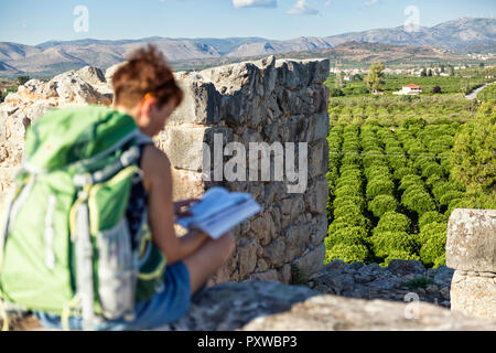 Griechenland, Peloponnes Argolis, Tiryns, archäologische Stätte, weiblichen Touristische lesen Reiseführer Stockfoto