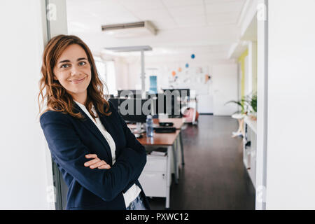 Zuversichtlich Geschäftsfrau ständigen lächelnd im Büro Stockfoto