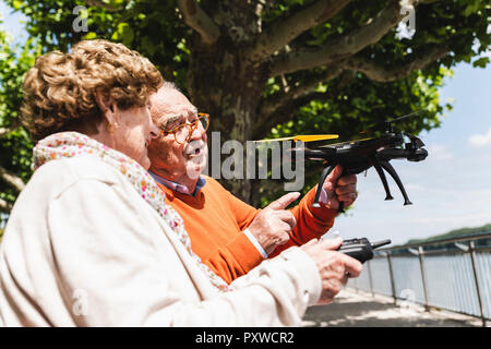 Senior Paar spielen mit einer Drohne in Park Stockfoto