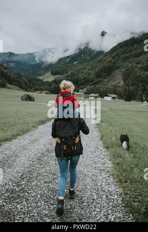 Österreich, Vorarlberg, Mellau, Mutter mit Kleinkind auf den Schultern auf einer Reise in die Berge Stockfoto