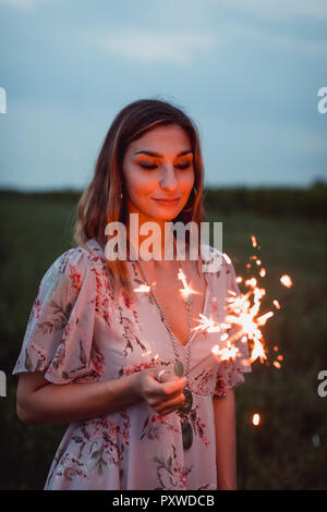 Junge Frau in Natur, brennende wunderkerze am Abend Stockfoto