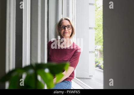 Portrait von zuversichtlich, reife Frau am Fenster Stockfoto