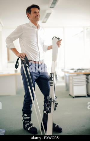 Geschäftsmann Skifahren im Büro Stockfoto