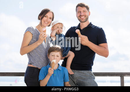 Glückliche Familie mit zwei Kindern Eis essen Stockfoto