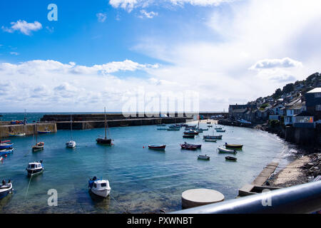 Breite Schrägansicht von Mousehole Harbour in Cornwall zeigt das Wasser bei Flut mit vielen kleinen schaukelnden Boote. Stockfoto