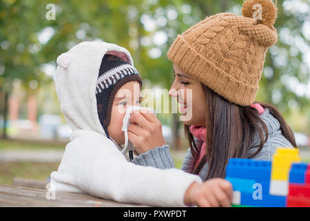 Mutter Nase für ihre Tochter blasen Stockfoto