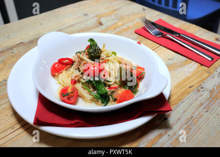 Linguine mit Krabbenfleisch mit Rucola, Tomaten und Chili, mit Olivenöl in einem Restaurant Einstellung fertig Stockfoto