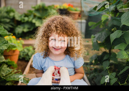 Portrait von glücklichen kleinen Mädchen Fütterung Hühner in Zuteilung Stockfoto