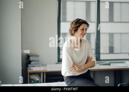 Erfolgreiche Geschäftsfrau sitzen am Schreibtisch in Ihrem Büro Stockfoto