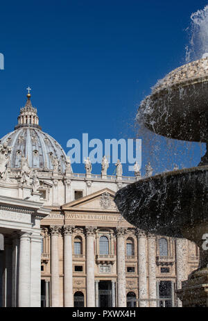 Piazza San Pietro in Rom zeigt die Fassade und die Kuppel des Petersdoms, der Brunnen von Bernini auf der rechten Seite. Statuen der Heiligen Linie der Fassade. Stockfoto