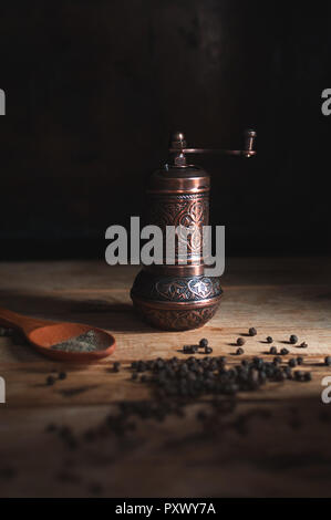 Vintage Kupfer Pfeffer Mühle auf Holz- Hintergrund Stockfoto