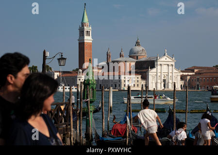 Ansicht von Venedig in Richtung Insel Kloster San Giorgio Maggiore. Im Vordergrund Touristen organisieren eine Gondelfahrt und entlang bummeln. Stockfoto