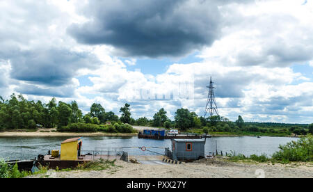 Blick auf den Fluss Pripyat auf dem Hintergrund der blauen Himmel und weißen Wolken. Ferry Service für den Transport von Personen, Fahrzeugen und Waren durch Wasser Stockfoto