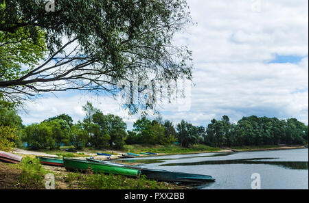 Pier mit alten Fischerboote am Ufer des Flusses Pripyat in der Nähe des Dorfes Petrikov Dorf. Reise nach Belarus. Wasser Landschaft Stockfoto