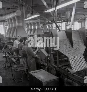1950, historische, weibliche Arbeitnehmer in der Produktion an der stets bereit ist, Batterie Werk in Forest Road, Walthamstow, London, England, UK. Stockfoto