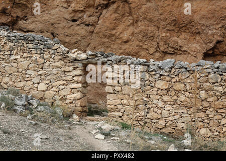 Eine Zuflucht für die Hirten und Tiere aus Stein Trockenbau in einer Höhle in der Red eisenhaltiges Gestein des Barranco de la Hoz Seca Canyon, Zaragoza, Spanien Stockfoto