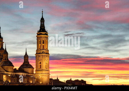 Eine Landschaft von einem Glockenturm der pilar Kathedrale beleuchtet bei Sonnenuntergang, nach einem Sturm, in einem trüben Herbst, mit rosa Wolken, in Saragossa, Spanien Stockfoto