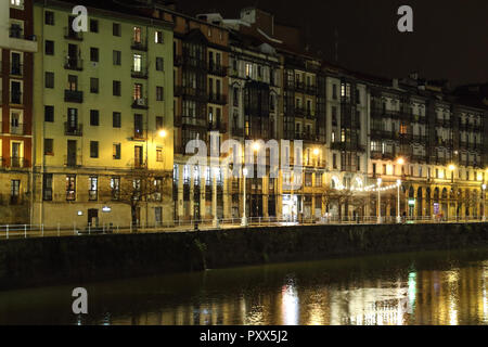 Die Ufer Gasse (Paseo de la Ribera) in Bilbao, Baskenland, Spanien, während eines Winters Nacht, mit typisch baskische Häuser mit gelben Lichter spiegeln Stockfoto