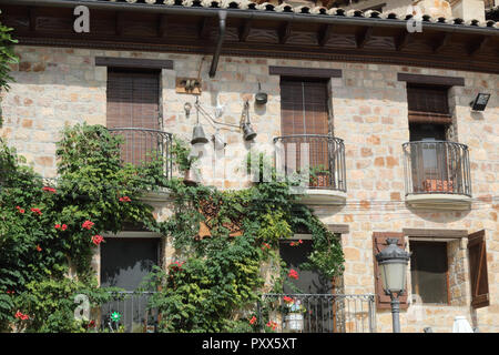 Typisch ländlichen Stein Haus mit Holzfenster, schmiedeeiserne Geländer und Klettern Efeu in Alquezar, Aragon, Spanien Stockfoto