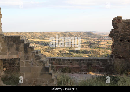 Die gepflügten Feldern der Region Aragon aus einem zerstörten Stein Verteidigung Mauern des verlassenen Montearagon schloss gesehen, bei Sonnenuntergang, in Spanien Stockfoto