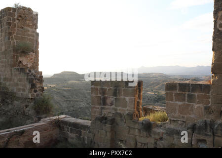 Die gepflügten Feldern der Region Aragon aus einem zerstörten Stein Verteidigung Mauern des verlassenen Montearagon schloss gesehen, bei Sonnenuntergang, in Spanien Stockfoto