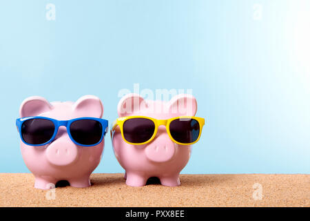 Zwei pink Piggy banks an einem Strand mit Sonnenbrille. Platz für Kopieren. Stockfoto