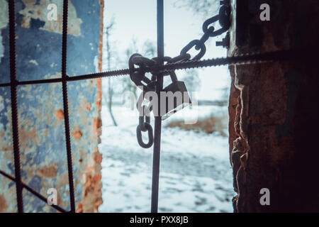 Vorhängeschloss und stabile Kette umwickelt Metallstäbe auf Fenster Stockfoto