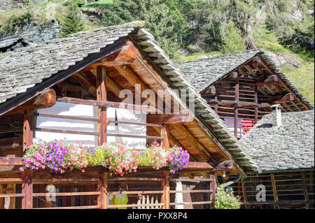 Eine typische Deutschsprachigen Walser Lodge, aus Stein mit Brett geschützt Holzbalkons, im Sommer, im Val d'Otro Tal, Alpen, Italien Stockfoto