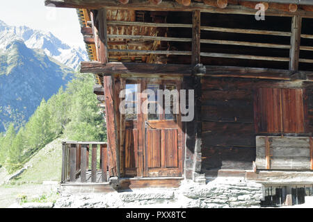 Eine typische Deutschsprachigen Walser Lodge, aus Stein mit Brett geschützt Holzbalkons, im Sommer, im Val d'Otro Tal, Alpen, Italien Stockfoto