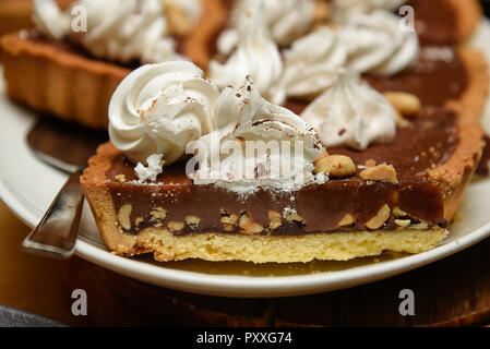 Schokolade Torte Torte mit Nüssen und Sahne obendrauf. Stockfoto