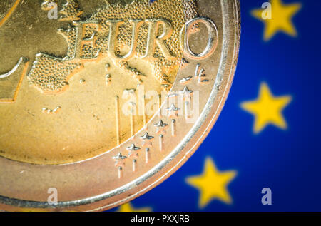 2 Euro Münze mit einer unscharfen Fahne der Europäischen Union auf dem Hintergrund Stockfoto
