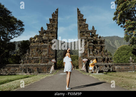 Frau zu Fuß durch Bali traditionellen Gate Stockfoto