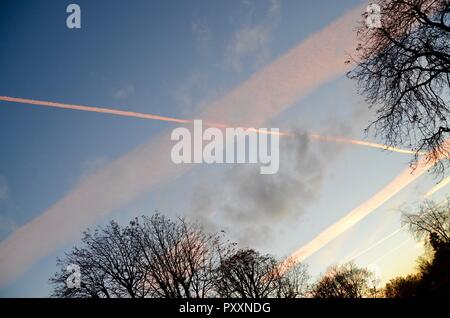 Kondensstreifen farbige Pink von Sonnenuntergang über London England links Stockfoto