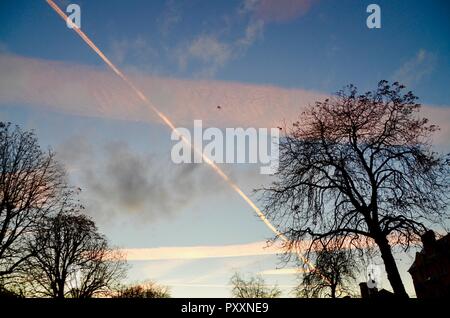 Kondensstreifen farbige Pink von Sonnenuntergang über London England links Stockfoto