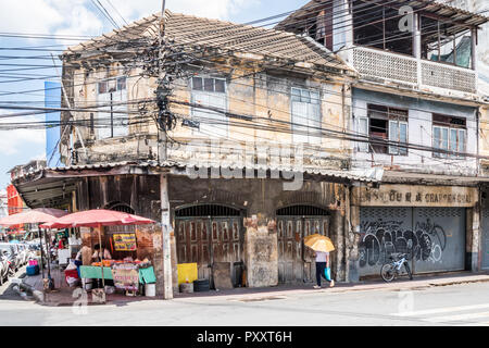 Bangkok, Thailand - 26. September 2018: eine Frau mit Regenschirm Wanderungen vorbei an verlassenen Geschäften in Chinatown. Die Gegend ist sehr alt und durch für redevlopment. Stockfoto