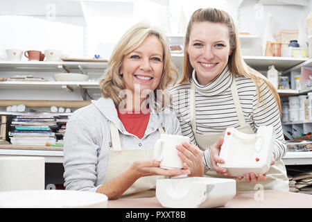 Portrait von Lehrer Mit reife Frau, die Becher in Keramik Klasse Stockfoto