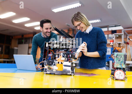 Junge attraktive Studierende der Mechatronik, die am Projekt Stockfoto