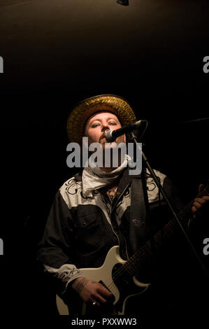 Paul Kategorie Engel Solospiel auf Gitarre, Gesang und kazoo am 2018 Stoke Newington Musikfestival in der Mascara Bar in seiner Signatur Strohhut Stockfoto