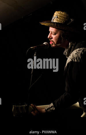 Paul Kategorie Engel Solospiel auf Gitarre, Gesang und kazoo am 2018 Stoke Newington Musikfestival in der Mascara Bar in seiner Signatur Strohhut Stockfoto