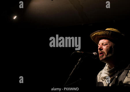 Paul Kategorie Engel Solospiel auf Gitarre, Gesang und kazoo am 2018 Stoke Newington Musikfestival in der Mascara Bar in seiner Signatur Strohhut Stockfoto