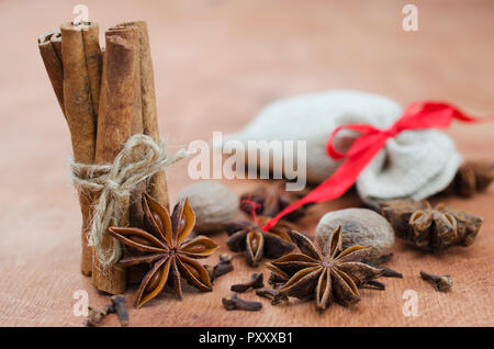 Gewürze für Glühwein. Nahaufnahme von Zimtstangen, Anis Sterne und Nelken auf Holz- Hintergrund. Selektive konzentrieren. Makro mit flachen Freiheitsgrad. Stockfoto
