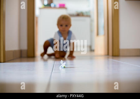 Happy Baby Boy kriechen die Schnuller in Eingang zu ergreifen Stockfoto