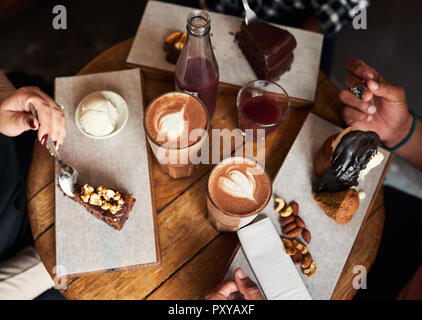 Freunde essen Desserts und Kaffee trinken zusammen in einem Cafe Stockfoto