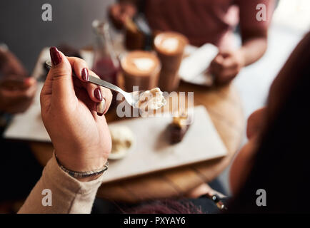 Junge Frau Eis essen mit Freunden in einem Cafe Stockfoto