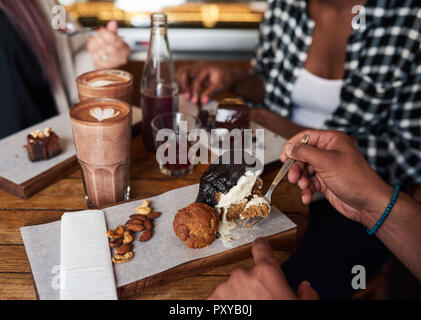 Freunde genießen, Desserts und Kaffee zusammen um ein Cafe Tabelle Stockfoto