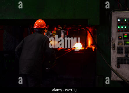 Industrielle Arbeiter in der Fabrik schweißen Nahaufnahme. Heiße Eisen in den weiterverarbeitenden Betrieben, die ein Arbeitnehmer statt. Das Schmelzen des Metalls in der Gießerei. Schwere schmieden steelmaki Stockfoto